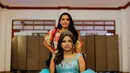 Juleydi Castillo bersama ibunya bersiap mengikuti perayaan ulang tahun massal untuk pasien kanker di Managua, Nikaragua, Sabtu (21/10). Para perempuan penderita kanker yang kurang beruntung secara ekonomi merayakan ultah mereka ke-15. (INTI OCON/AFP)