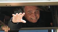Mantan Presiden Brasil Jair Bolsonaro melambai kepada pendukungnya di markas Partai Liberal di Brasilia, Brasil, Kamis (30/3/2023). (AP Photo/Eraldo Peres)
