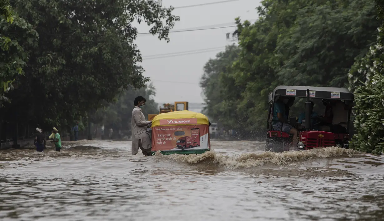 Sebuah kendaraan melintasi jalan yang tergenang air setelah hujan monsun di Gurgaon di pinggiran New Delhi (19/8/2020). Jumlah korban dari banjir tahunan di seluruh Asia Selatan naik menjadi hampir 1.300. (AFP/Xavier Galiana)