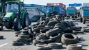 Petani Perancis memblokir jalan raya A6 dengan traktor dan ban di Limonest, dekat Lyon, Prancis (23/7/2015). Petani Perancis memprotes kembali ketidak seimbangan keuntungan yang diperoleh antara petani dan pengecer. (REUTERS/Robert Pratta)