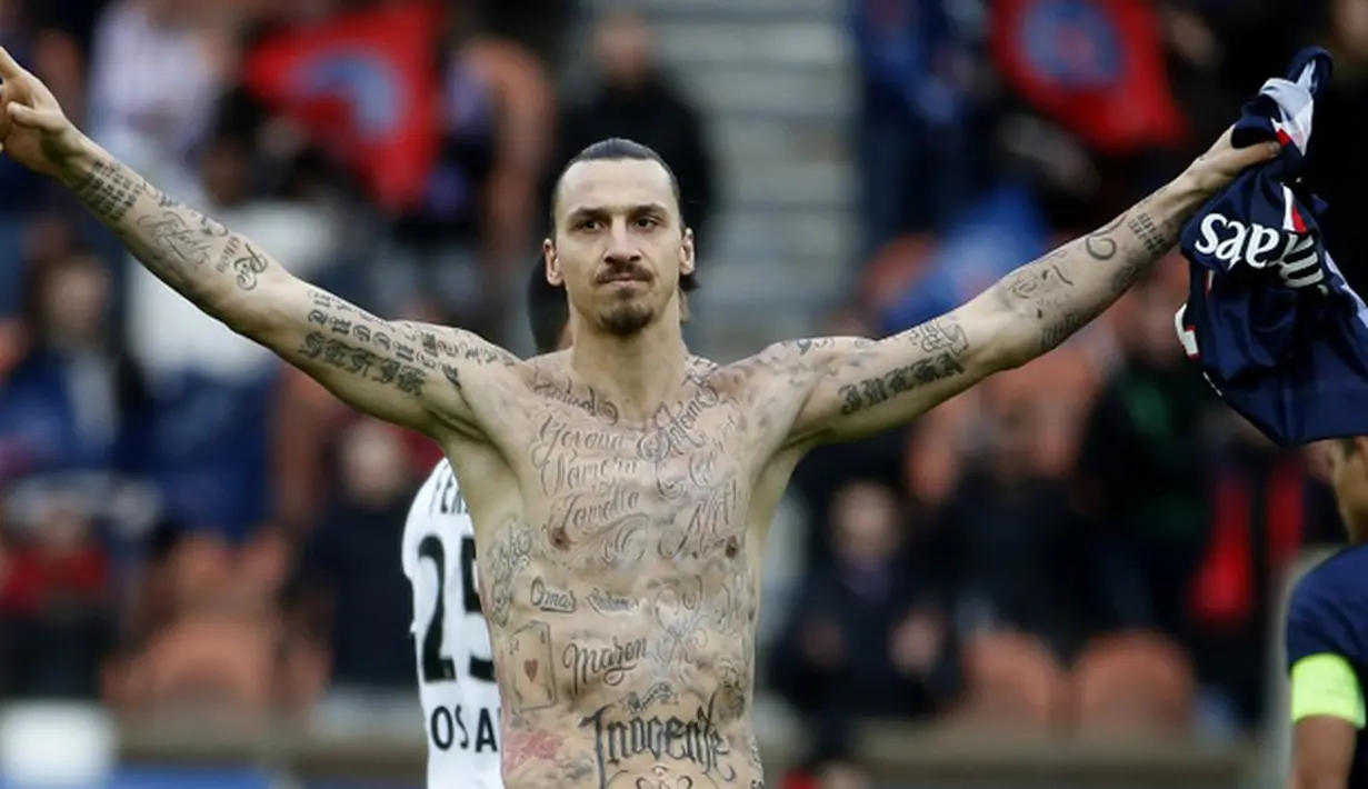 Penyerang Paris Saint-Germain Zlatan Ibrahimovic merayakan selebrasi pamer tato saat timnya bermain imbang 2-2 dengan Caen pada 14 Februari 2015. (AFP Photo/Kenzo Tribouillard)