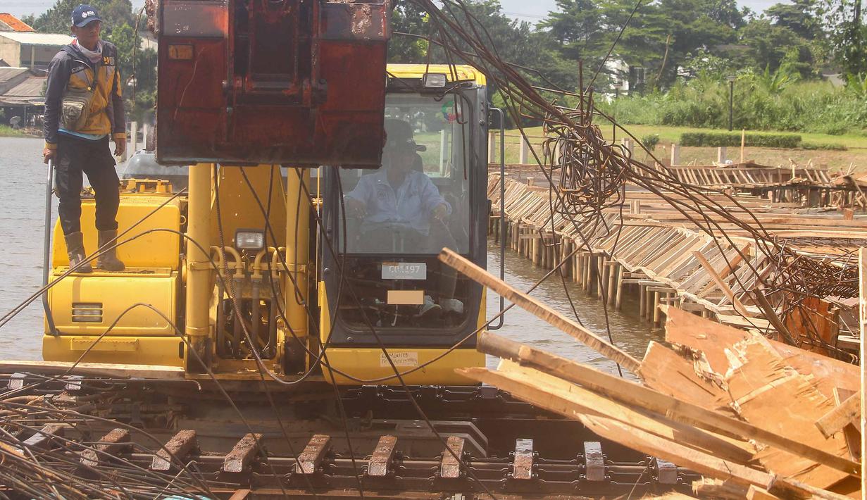 Koordinasi lintas instansi dilakukan untuk melindungi aset lingkungan dan mencegah praktik pembangunan yang melanggar aturan di kawasan situ. Tampak dalam foto, petugas Dinas Sumber Daya Air Pemerintah Provinsi Jawa Barat membongkar tiang pancang beton yang dipasang di Setu Tujuh Muara, Sawangan, Depok, Senin (16/01/2026). (Merdeka.com/Arie Basuki)