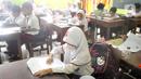 Siswa mengikuti ujian penilaian akhir semester (PAS) yang dihadiri guru pengawas di SDN Pondok Cina 1 Depok, Jawa Barat, Senin (5/12/2022). Ujian akhir tersebut dilakukan seluruh siswa baik dari kelas 1 hingga kelas 6 SD. (merdeka.com/Arie Basuki)