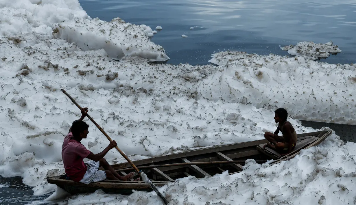 Dua anak India duduk di atas perahu mengarungi sungai Yamuna yang tercemar polusi di New Delhi, 21 September 2018. Akibat pertumbuhan populasi dan industrialisasi, Sungai Yamuna menjadi salah satu sungai paling tercemar di dunia. (AFP/CHANDAN KHANNA)