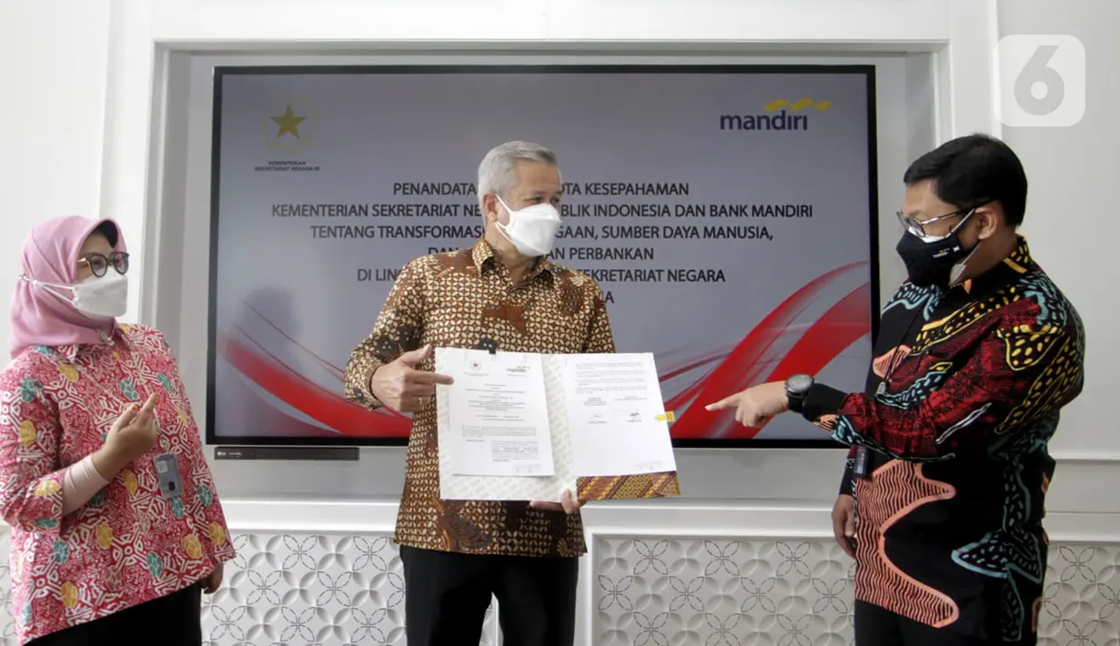 Direktur Hubungan Kelembagaan Bank Mandiri Rohan Hafas (tengah) menunjukkan naskah MoU Kerjasama Kemensetneg dan Bank Mandiri saat berbincang dengan SVP Government Solutions Dwi Rihandjani (kiri) dan Corporate Secretary Rudi As Aturridha di Jakarta, Kamis (15/7/2021). (Liputan6.com/HO/Mandiri)