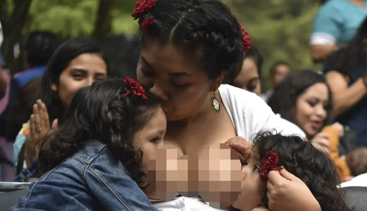 Ibu-ibu menyusui anak mereka selama festival menyusui "Big latch On" yang diadakan di Bonatic Garden of the Chapultepec Park di Mexico City, Meksiko (5/8). Festival ini bertujuan untuk mempromosikan dukungan menyusui secara global. (AFP Photo/Yuri Cotez)
