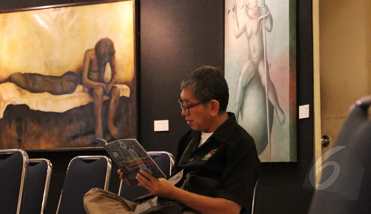 Pengunjung membaca katalog di depan lukisan pada acara pembukaan pameran 4 pelukis bersama yang bertajuk "Spirit Indonesia", di Galeri Cipta 3, TIM, Jakarta, Sabtu (7/3). Pameran tersebut berlangsung hingga 15 Maret 2015. (Liputan6.com/Helmi Afandi)