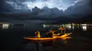 Seorang tukang perahu Kashmir kembali di tepi danau Dal setelah bekerja seharian, di Srinagar, Kashmir yang dikuasai India, Minggu (1/8/2021). Danau terbesar kedua di propinsi Jammu dan Kashmir ini merupakan pusat pariwisata dan rekreasi. (AP Photo/Mukhtar Khan)