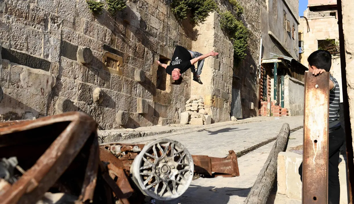 Seorang pemuda melompat berlatih parkour di Aleppo, Suriah, (7/4). Para pemuda memanfaatkan reruntuhan bangunan akibat perang menjadi tempat untuk melatih kelincahannya bermain Parkour. (AFP Photo/George Ourfalian)