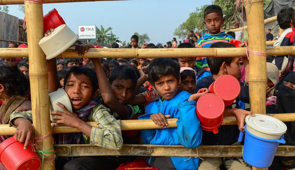 Anak-anak pengungsi muslim Rohingya menunggu bantuan makanan di kamp pengungsi Thankhali di Distrik Ukhia, Bangladesh, (12/1). Mereka melarikan diri bersama orangtuanya saat konflik pecah di Myanmar. (Munir UZ ZAMAN/AFP)