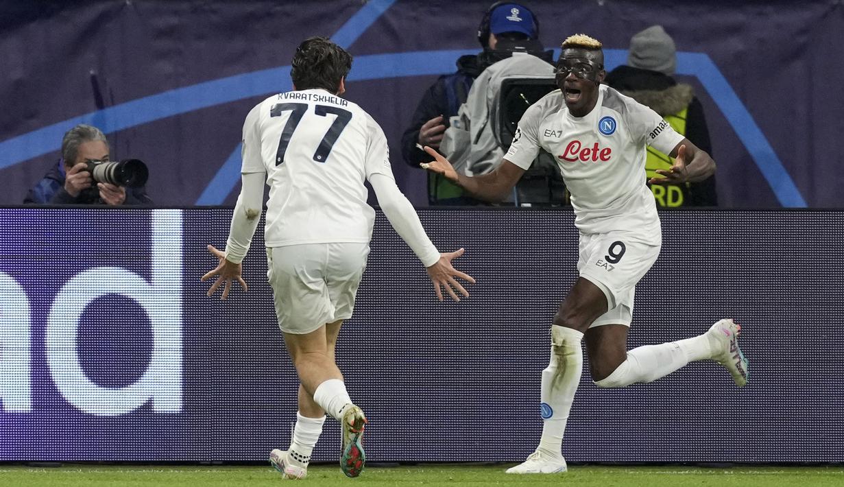 <p>Pemain Napoli, Victor Osimhen (kanan) merayakan gol pertama timnya ke gawang Eintracht Frankfurt bersama Khvicha Kvaratskhelia pada laga leg pertama 16 besar Liga Champions 2022/2023 yang berlangsung di Deutsche Bank Park, Rabu (22/2/2023) WIB. (AP Photo/Michael Probst)</p>