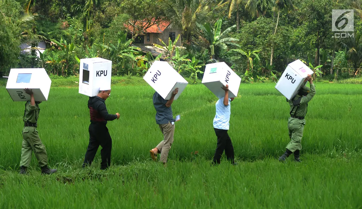 Petugas KPPS membawa logistik Pemilu 2019 melintasi sawah menuju TPS di Desa Cidokom, Bogor, Selasa (16/4). Dalam hitungan jam, lebih dari 200 juta penduduk Indonesia akan segera menyalurkan hak pilihnya dengan mendatangi TPS yang tersebar di 34 Provinsi di Tanah Air. (Merdeka.com/Arie Basuki)