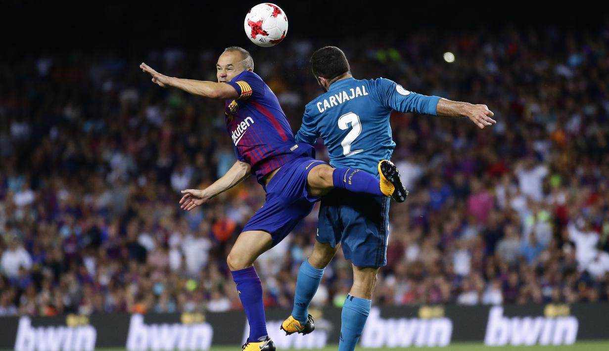 Duel pemain FC Barcelona, Andres Iniesta (kiri) dan pemain Real Madrid, Carvajal pada laga Supercup Spanyol di Camp Nou stadium, Barcelona, (13/8/2017). Real Madrid menang 3-1. (AP/Manu Fernandez)
