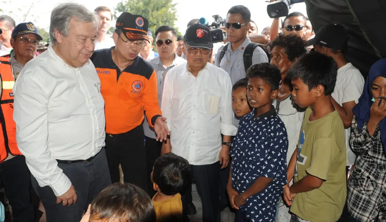 Wakil Presiden Jusuf Kalla dan Sekretaris Jenderal PBB Antonio Guterres mendengarkan penjelasan Kepala BNPB Willem Rampangilei (tengah) saat menemui korban gempa dan tsunami Palu di Sulawesi Tengah, Jumat (12/10). (Liputan6.com/HO/Tim Media Wapres)