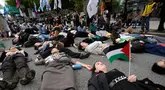 Sejumlah warga yang menyatakan solidaritas terhadap Palestina berbaring di jalan saat mengikuti aksi yang mengecam tindakan militer Amerika Serikat dan Israel di Gaza, di Seoul, Korea Selatan, Sabtu (3/10/2026). Aksi die-in tersebut dilakukan sebagai simbol untuk menggambarkan korban konflik di Gaza. Para peserta berkumpul dan menyampaikan dukungan terhadap Palestina dalam unjuk rasa yang berlangsung di kawasan pusat Kota Seoul. (AP Photo/Ahn Young-joon)