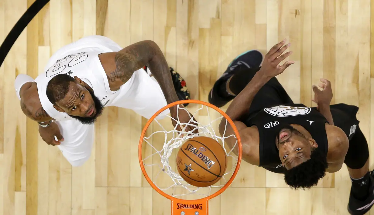 LeBron James (kiri) dan Joel Embiid melihat bola yang masuk ke dalam keranjang pada laga NBA All-Star basketball game di Los Angeles, (18/2/2018). Tim LeBron menang 148-145. (Mike Nelson/Pool via AP)