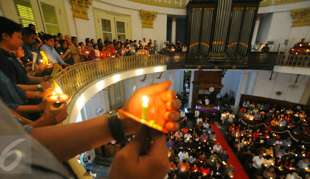 Umat Kristiani menyalakan lilin pada misa malam Natal di Gereja Immanuel, Jakarta  Sabtu (24/12). Perayaan natal berlangsung khidmat. (Liputan6.com/Angga Yuniar)