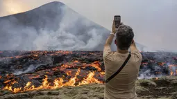 Pihak berwenang di Islandia pada hari Selasa memperingatkan para turis dan penonton lainnya untuk menjauh dari gunung berapi yang baru saja meletus dan memuntahkan lava dan gas berbahaya dari celah di barat daya negara itu. (AP Photo/Marco Di Marco)