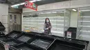 Pengunjung melewati rak-rak kosong dan lemari es saat warga yang panik menimbun makanan di supermarket Hong Kong, Jumat (4/3/2022). Pemimpin Hong Kong awal pekan ini mengatakan mobilitas orang mungkin dibatasi selama tes covid-19 massal wajib ketika kasus harian mencapai rekor. (AP Photo/Kin Cheung)