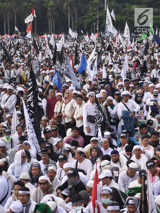 Umat muslim mengikuti aksi reuni 212 di kawasan silang Monas, Jakarta, Minggu (2/12). Bendera dan panji-panji terlihat diusung para peserta aksi reuni akbar 212. (Liputan6.com/Herman Zakharia)