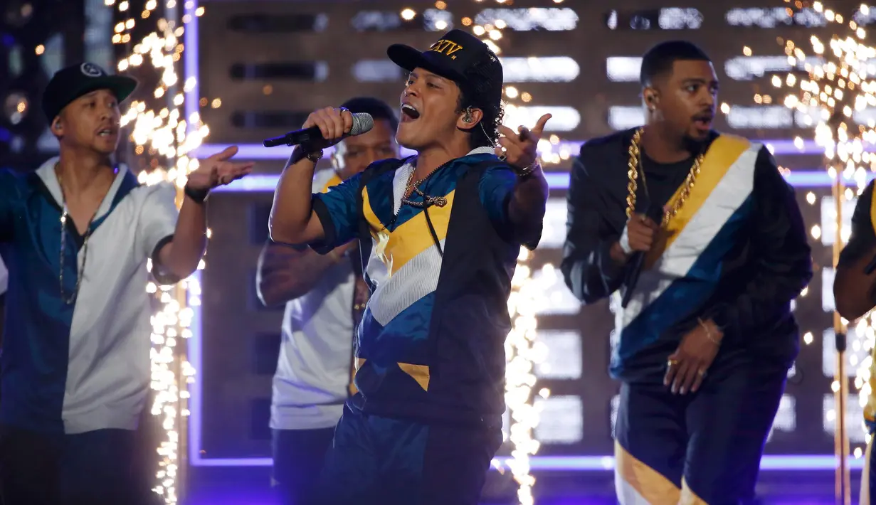 Bruno Mars ditemani penari latarnya membuka ajang tahunan American Music Awards (AMA) 2016 di Los Angeles, California, Minggu (20/11). Membawakan lagu terbarunya, 24K MagiC, Bruno Mars membuat panggung AMA 2016 seketika bergoyang. (REUTERS/Mario Anzuoni)