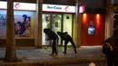 Demonstran menyerbu cabang bank saat memprotes penangkapan rapper Pablo Hasel di Barcelona, Spanyol, Selasa (16/2/2021). Aksi protes meletus di Spanyol setelah polisi menangkap Pablo Hasel yang menolak hukuman penjara karena menghina kerajaan dan memuji terorisme. (AP Photo/Emilio Morenatti)