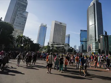 Warga beraktifitas saat berlangsungnya Hari Bebas Kendaraan Bermotor (HBKB) di kawasan Bunderan HI, Jakarta, Minggu (24/12). Pemprov DKI Jakarta tetap memberlakukan HBKB saat libur panjang Natal 2017 dan tahun baru 2018. (Liputan6.com/Faizal Fanani)