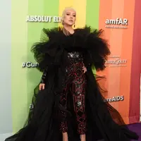 Penyanyi Christina Aguilera berpose saat tiba menghadiri 10th amfAR Gala di Los Angeles, California (11/10/2019). Aguilera tampil anggun dengan gaun hitam serta celana merah berkilau. (AFP Photo/Gregg DeGuire)