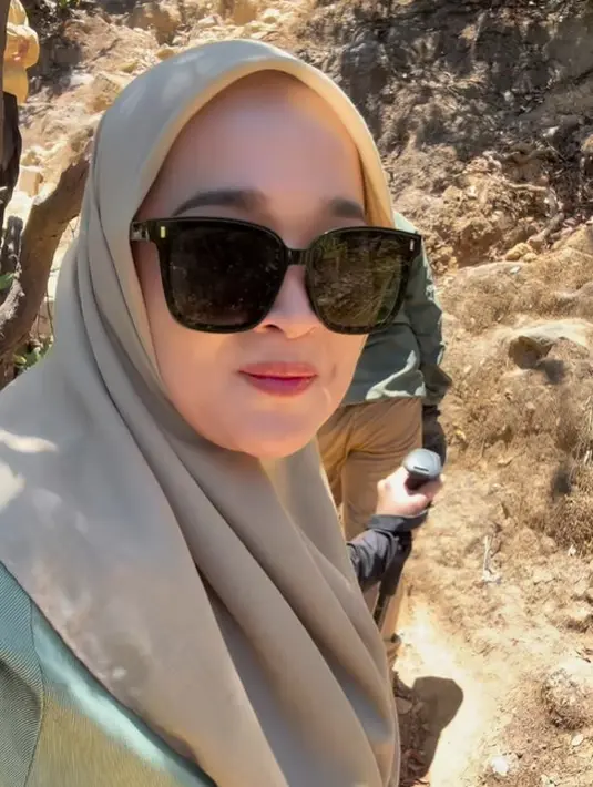 Tak ketinggalan, Ririe juga membawa kacamata hitam untuk melindungi matanya dari sinar matahari yang menyengat. [Foto: Instagram/ririe_fairus]