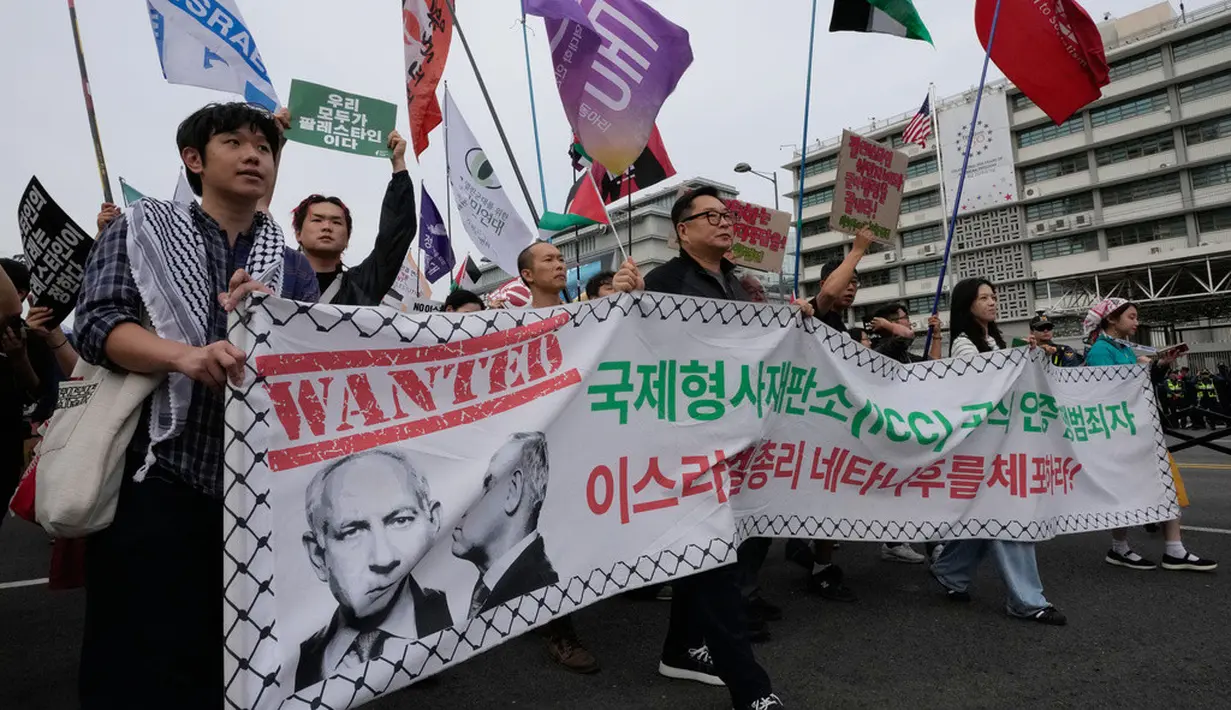 Warga yang menyatakan solidaritas terhadap Palestina melintas di depan Kedutaan Besar Amerika Serikat saat mengikuti aksi yang mengecam tindakan militer AS dan Israel di Gaza, di Seoul, Korea Selatan, Sabtu (3/10/2026). Para peserta membawa sejumlah atribut dukungan terhadap Palestina sambil berjalan melewati kawasan pusat kota. Aksi tersebut merupakan bagian dari rangkaian unjuk rasa yang menyuarakan perhatian terhadap situasi di Gaza. (AP Photo/Ahn Young-joon)