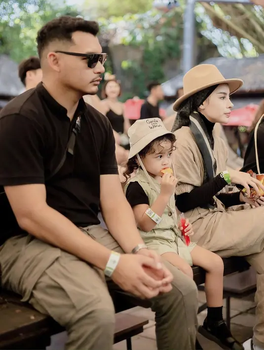 Gemasnya Aghnia Punjabi bersama sang suami dan Baby Cana sedang berada di kebun binatang mengenakan outfit safari yang kompak. Aghnia Punjabi dan Baby Cana kompak menumpuk inner hitam dengan jumpsuit cokelat dan topi lebar yang serasi. [Foto: Instagram/emyaghnia]