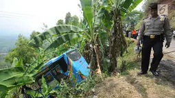 Petugas kepolisian berjalan dekat bus maut Jakarta Wisata Transport yang masuk jurang di jalur alternatif Cikidang, Sukabumi, Minggu (9/9). Bus pariwisata tersebut mengangkut 31 karyawan PT Catur Putra Raya Bogor dan dua awak. (Merdeka.com/Arie Basuki)