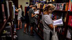 Pengunjung melihat buku di toko buku "El Ateneo Grand Splendid" di Buenos Aires, Argentina pada Rabu (9/1). Pada 2019, El Ateneo Grand Splendid dinobatkan sebagai toko buku terindah nomor dua di dunia oleh National Geographic. (RONALDO SCHEMIDT / AFP)