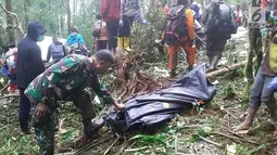 Personel TNI memegang kantung jenazah dekat pesawat Dimonim PK-HVQ yang jatuh di Kabupaten Pegunungan Bintang, Papua, Minggu (12/8). Korban selamat atas nama Jumadi (12) mengalami luka patah pada tangan sebelah kanan. (Liputan6.com/HO/Humas Polda Papua)