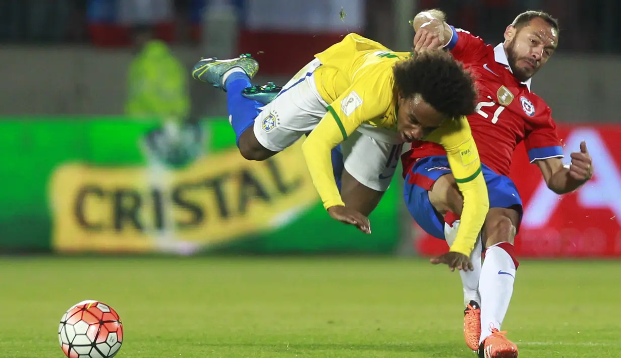 Pemain Brazil Willian (kiri) terjungkal saat berebut bola dengan pemain Chile Marcelo Diaz pada laga kualifikasi Piala Dunia 2018 di Santiago, Chile, Kamis (08/10/2015). Chile menang 2-0.   (AFP Photo / Claudio Reyes)