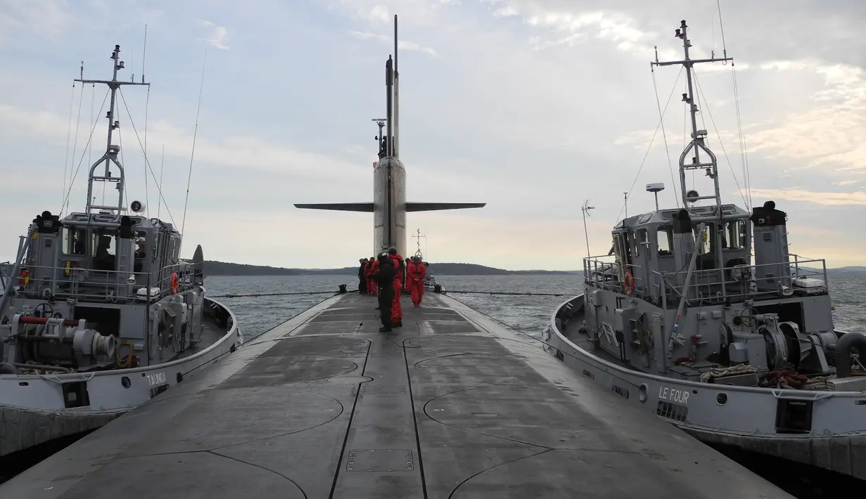 Para prajurit Angkatan Laut Perancis berbaris di atas kapal selam nukir Triumphant "Le Vigilant" yang dikawal oleh dua kapal tunda sebelum menjalankan misi penyelaman, Brest, Prancis (21/10). (AFP /Valérie Leroux )