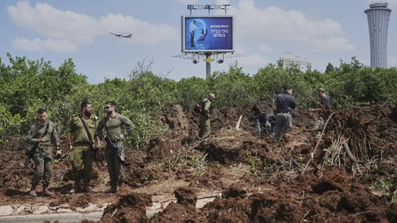 Pasukan keamanan Israel memeriksa lokasi tempat proyektil yang ditembakkan oleh kelompok Houthi dari Yaman mendarat di area Bandara Internasional Ben Gurion dekat Tel Aviv, Israel, pada Minggu (4/5/2025).
