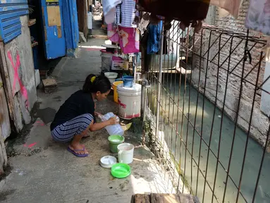 Warga mencuci peralatan dapur di belakang rumahnya yang berada di Gang Sekretaris, RT 015/RW 007 Tanjung Duren Utara, Jakarta Barat , Selasa (8/10/2019). Warga di kawasan tersebut tidak memiliki septic tank sehingga hajat yang dibuang langsung mengalir ke kali. (Liputan6.com/Herman Zakharia)