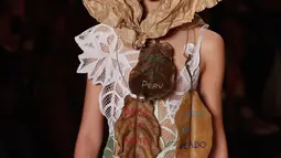 Seorang model mengenakan kertas cokelat atau yang biasa disebut kertas pembungkus di kepalanya saat membawakan rancangan karya Ronaldo Fraga dalam Sao Paulo Fashion Week di Brasil (26/4). (AP Photo / Andre Penner)