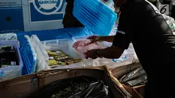 Petugas menata barang bukti narkoba sebelum pemusnahan di Gedung BNN, Jakarta, Jumat (1/3). BNN memusnahkan sebanyak 99,7 Kg sabu, 9.990 butir ekstasi dan 118,34 kg daun khat hasil tangkapan dari November 2018 - Januari 2019. (Liputan6.com/Faizal Fanani)