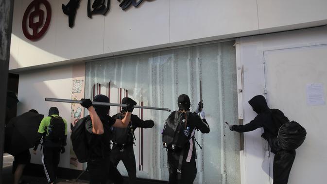 Demonstran merusak cabang Bank of China di Distrik Central, Hong Kong, Senin (11/11/2019). Ketegangan di Hong Kong semakin meningkat setelah polisi menembak seorang demonstran hingga kritis. (AP Photo/Kin Cheung)