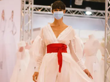 Seorang model yang mengenakan masker memperagakan gaun pengantin di pameran dagang European Bridal Week di Essen, Jerman, pada 5 Juli 2020. European Bridal Week, sebuah pameran dagang internasional tentang pernikahan, diselenggarakan mulai 4 hingga 6 Juli. (Xinhua/Tang Ying)