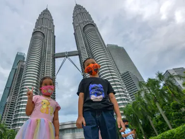Anak-anak yang mengenakan masker berpose untuk difoto di depan Menara Kembar Petronas di Kuala Lumpur, Malaysia, pada 3 Oktober 2020. Malaysia melaporkan tambahan 317 kasus terkonfirmasi COVID-19 pada Sabtu (3/10), sehingga totalnya bertambah menjadi 12.088. (Xinhua/Chong Voon Chung)