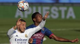 Penyerang Real Madrid, Eden Hazard, berebut bola dengan gelandang Huesca, Kelechi Nwakali, pada laga lanjutan Liga Spanyol di Stadion Alfredo Di Stefano, Sabtu (31/10/2020) malam WIB. Real Madrid menang 4-1 atas Huesca. (AP Photo/Manu Fernandez)
