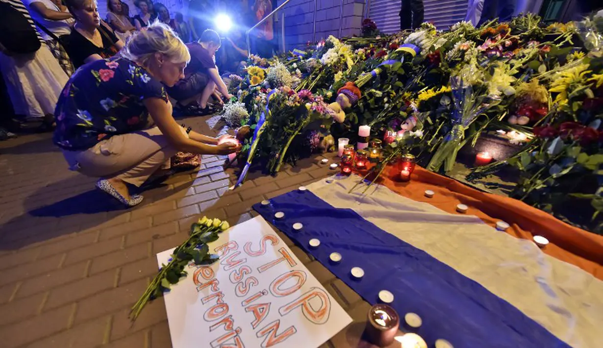 Seikat bunga diletakkan di atas kertas bertuliskan  "Stop Russian terrorism!" di depan Kedutaan Besar Belanda di Kiev, Ukraina, Jumat (17/7/14). (AFP PHOTO/Sergei Supinsky)