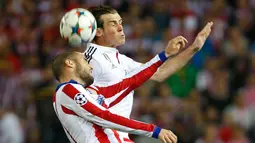 Gelandang Real Madrid, Gareth Bale berebut bola udara dengan pemain Atletico Madrid Mario Suarez di leg 8 besar Liga Champions di Vicente Calderon, Spanyol, Rabu (15/4/2015). Atletico Madrid bermain imbang 0-0 dengan Real Madrid. (Reuters/Juan Medina)