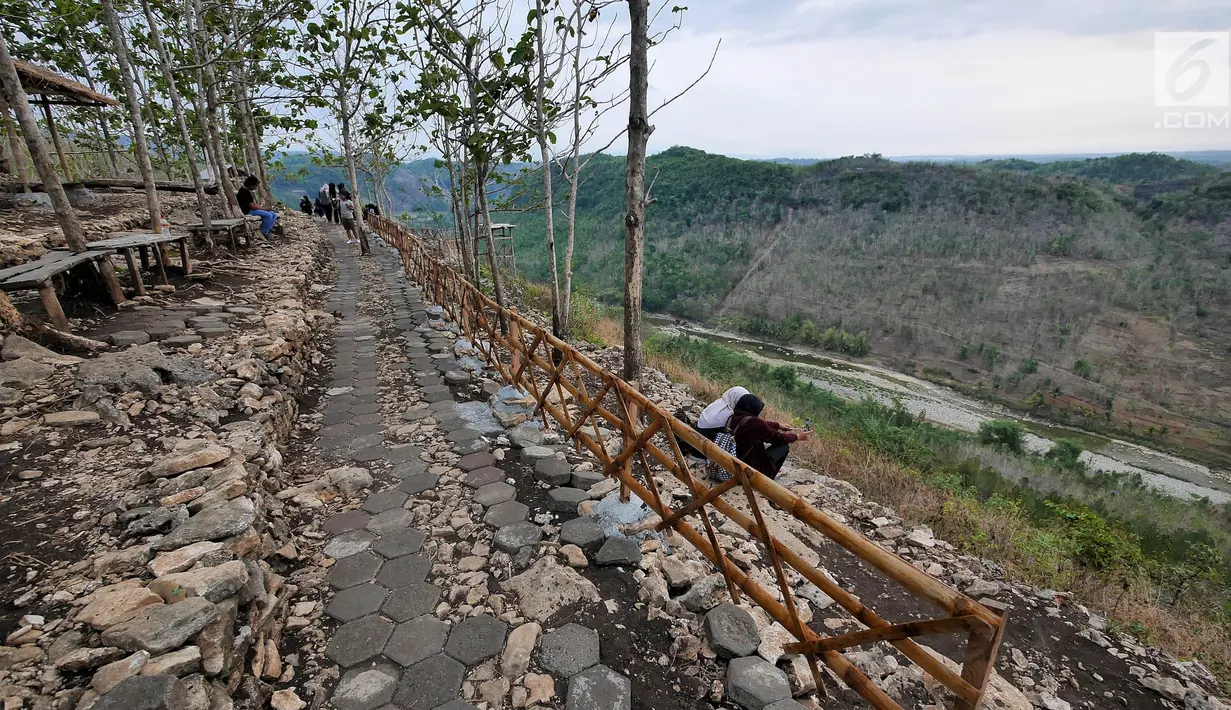 Wisatawan mengabdikan moment di Bukit Panguk Kediwung, Bantul, Yogyakarta (16/10). Bukit Panguk Kediwung dibuka untuk umum sekitar pertengahan 2016 oleh masyarakat setempat dan menawarkan keindahan sunrise di atas awan. (Liputan6.com/Herman Zakharia)