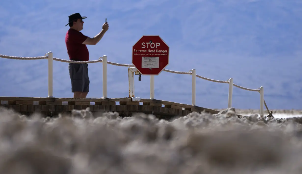 Sebuah tanda peringatan bahaya panas ekstrem di Badwater Basin, Taman Nasional Death Valley, Taman Nasional Death Valley, California, Kamis (1/9/2022). Nama Death Valley diberikan oleh para petualang yang hilang di kawasan ini, pada musim dingin tahun 1849 hingga 1850. (AP Photo/John Locher)