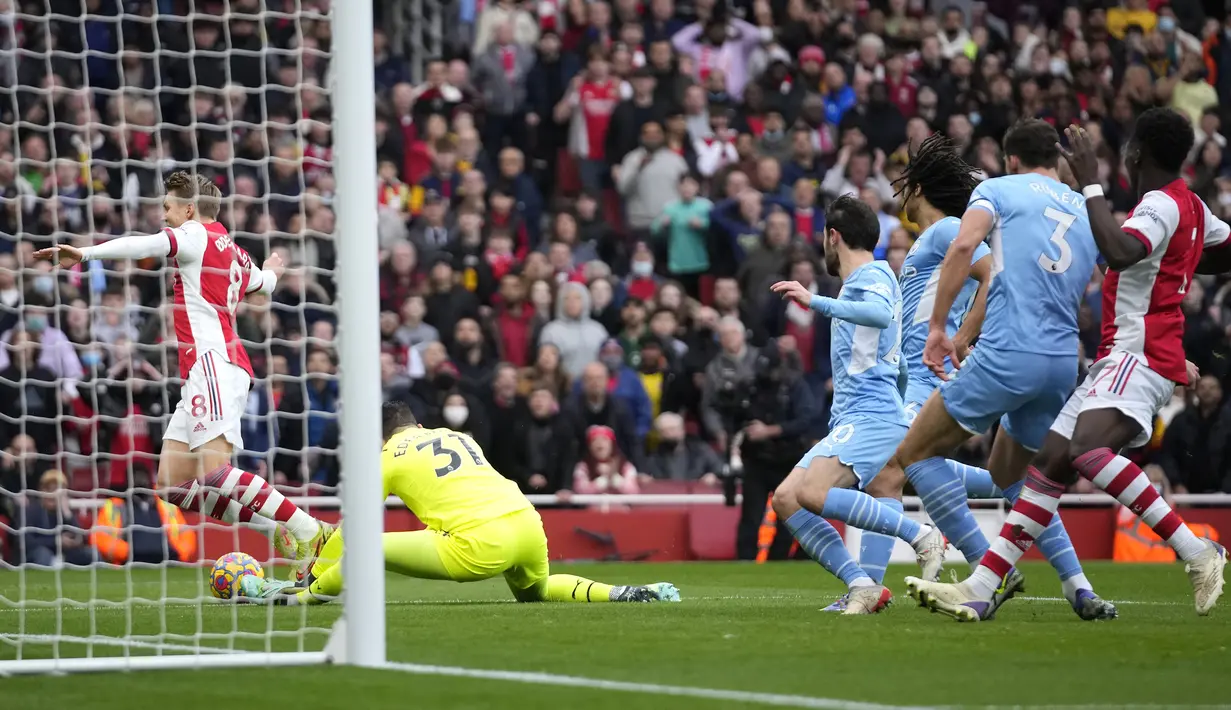 Pada menit ke-10 Arsenal nyaris memperoleh tendangan penalti. Martin Odegaard sekilas tampak dijatuhkan oleh kiper Manchester City Ederson di dalam kotak penalti. Usai memeriksa VAR, Ederson dinilai menyentuh bola terlebih dahulu. (AP/Matt Dunham)