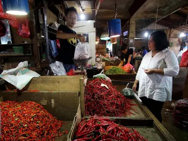 Seorang pedagang cabai melayani pembelinya di Pasar Impres Senen, Jakarta, Selasa (15/11). Kementrian Perdagangan akan menggelar operasi pasar melalui kemitraan dengan PT Perusahaan  Perdagangan Indonesia (Persero). (Liputan6.com/Gempur M. Surya)
